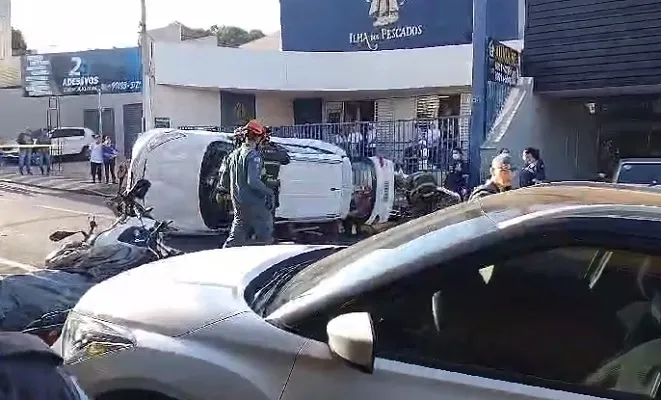Carro capota após bater em veículo estacionado em avenida